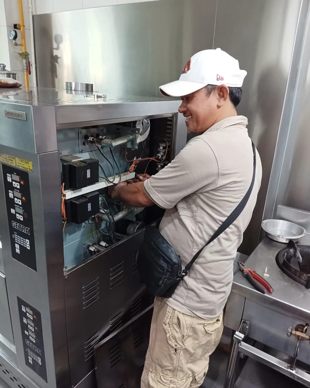 Teknisi sedang memperbaiki microwave